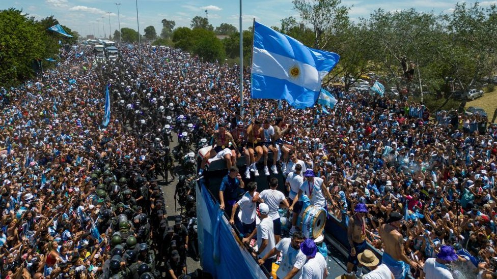 Hinchas miran el paso del bus