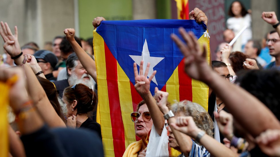 Supporters of Catalonia's independence hold an Estelada (Catalan separatist flag) as they gesture during a protest against the upcoming ruling of the Spanish Supreme Court, 13 October 2019