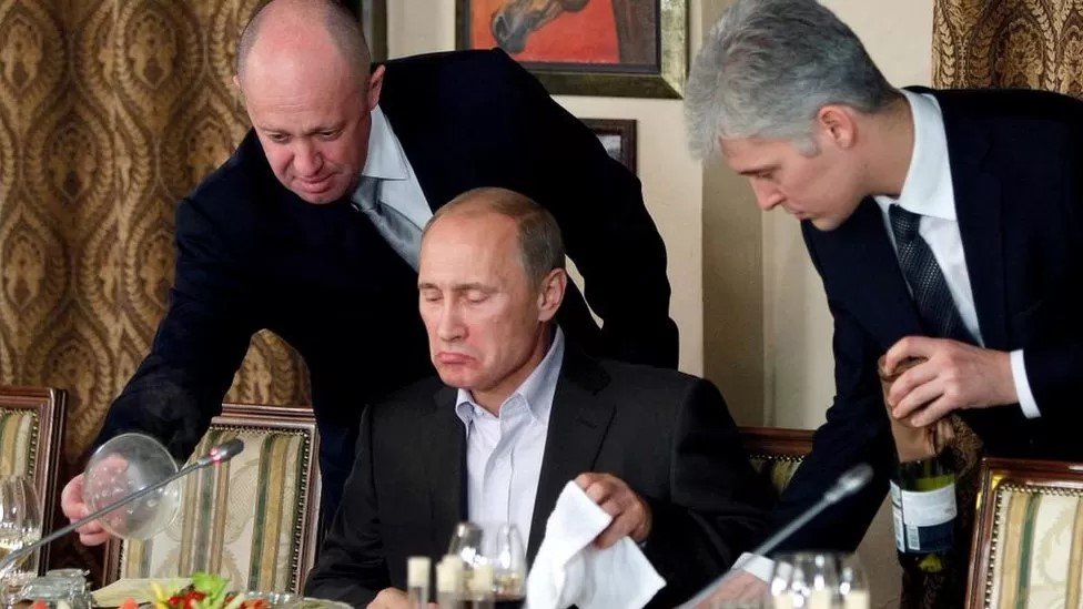 يفغيني بريغوزين (إلى اليسار) مع الرئيس الروسي (جالسا) في مأدبة عشاء عام 2011