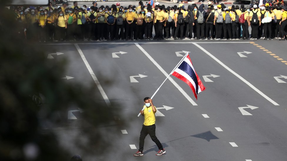 A royalist carries a flag of Thailand as pro-democracy demonstrators stage a Thai anti-government mass protest, on the 47th anniversary of the 1973 student uprising, in Bangkok, Thailand October 14,