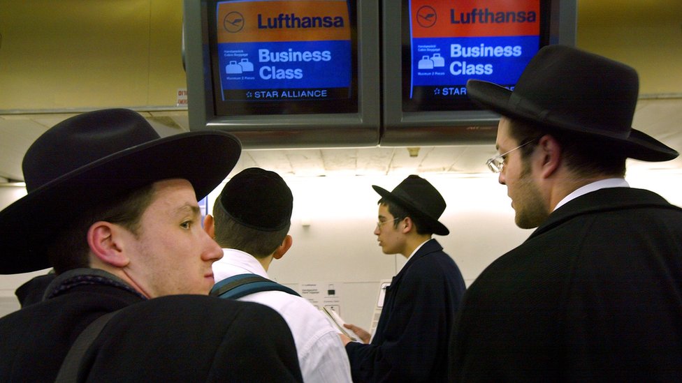 Las disputas por los asientos han causado durante años peleas y demoras en vuelos a Israel, según 'The Jerusalem Post'. Un grupo de hombres en un mostrador de un aeropuerto