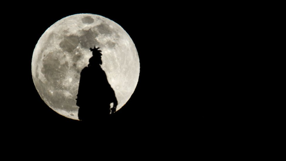 Vista de la luna de sangre de lobo tras la estatua del Capitolio de Estados Unidos.
