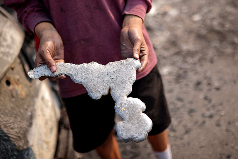 A man holds a piece of melted metal , Phoenix