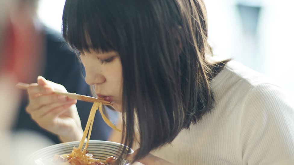 Mujer comiendo.