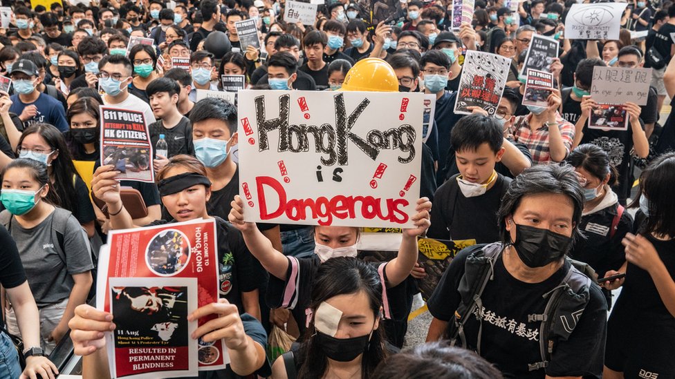 Протестующие занимают зал прибытия международного аэропорта Гонконга во время демонстрации 12 августа