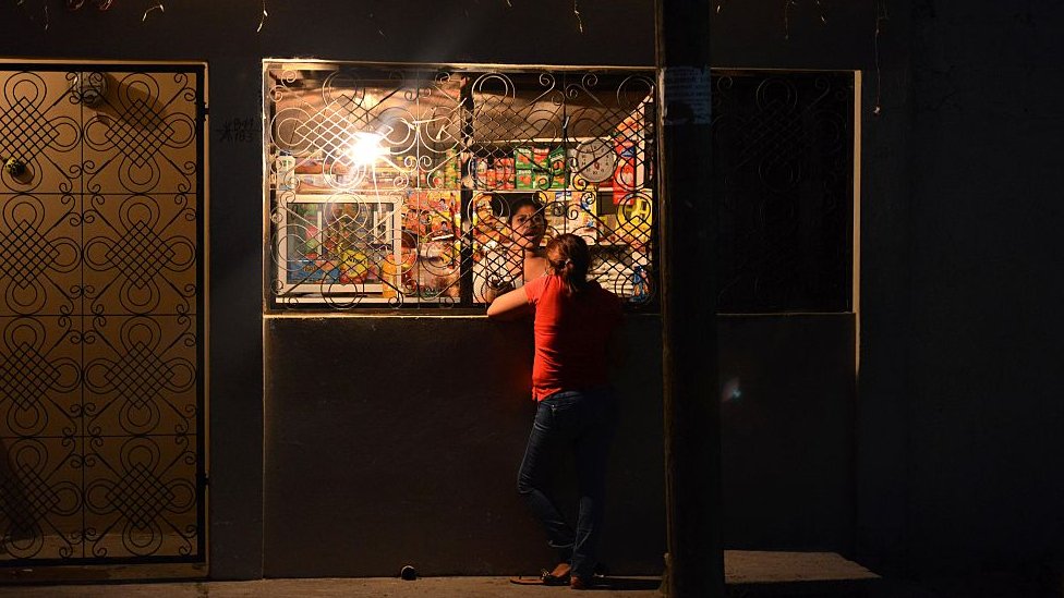Женщина делает покупки в магазине в районе Репарто Лемпира в Сан-Педро-Сула, в 240 км к северу от Тегусигальпы, Гондурас, 23 марта 2016 года. Семьи покидают район Сан-Педро-Сула после того, как им угрожала банда «Мара 18». члены, которые дали им на это 24 часа.