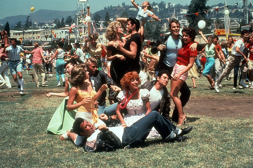 Olivia Newton-John y John Travolta como Sandy Olsson y Danny Zucko junto a otros actores en una escena de "Grease", película de 1978.