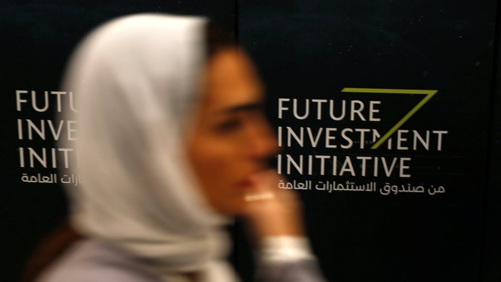 Женщина проходит мимо вывески во время конференции Future Investment Initiative в Эр-Рияде, Саудовская Аравия (24 октября 2017 г.)