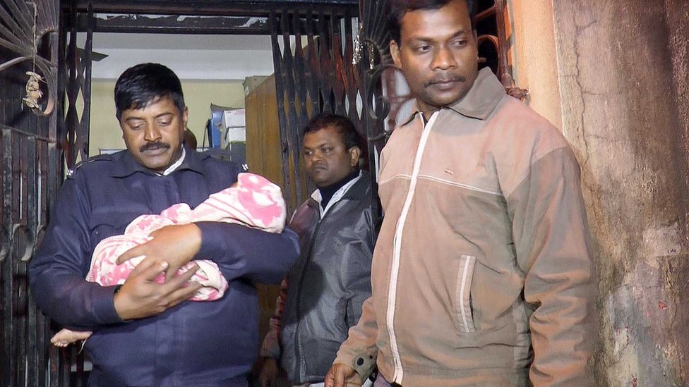 Полицейский забирает девочку из комнаты в Калькутте