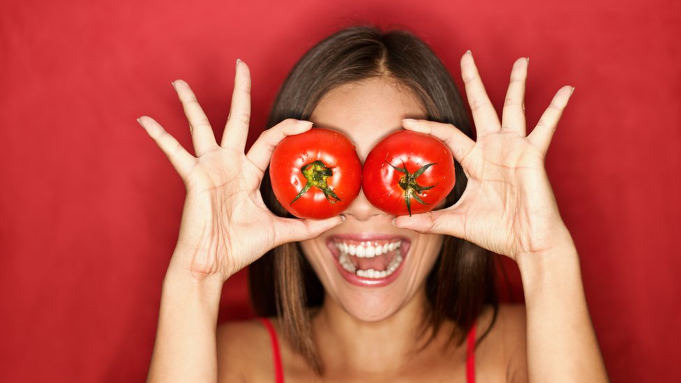 Mujer posando con tomates