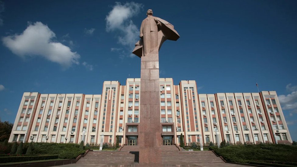 A large statue of Lenin in front of the Transnistrian Parliament building.