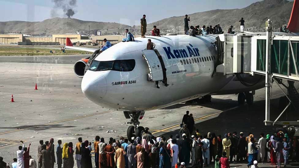 急欲逃離喀布爾的阿富汗群眾爬上一架停在喀布爾國際機場的客機（16/8/2021）