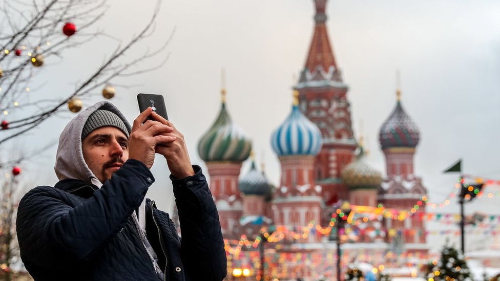 Un hombre tomando una foto en la Plaza Roja.