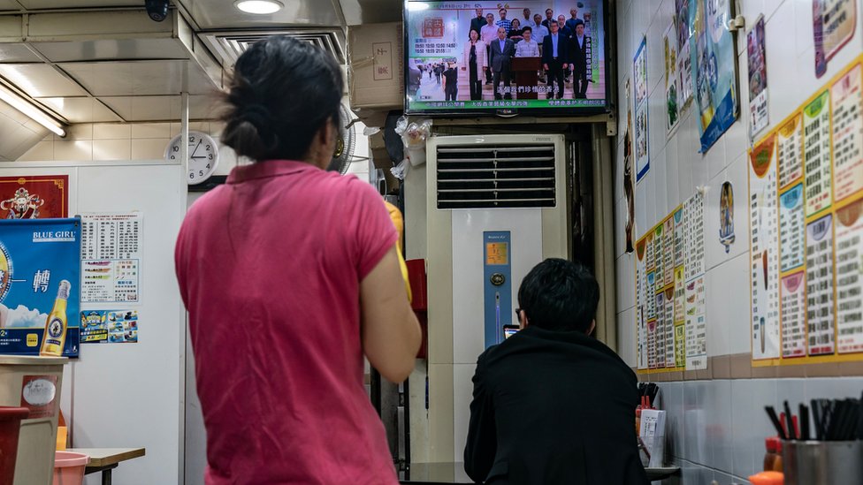 Клиенты смотрят повтор выступления генерального директора Гонконга Кэрри Лам в телевизионной трансляции в ресторане 5 октября 2019 года в Гонконге, Китай.