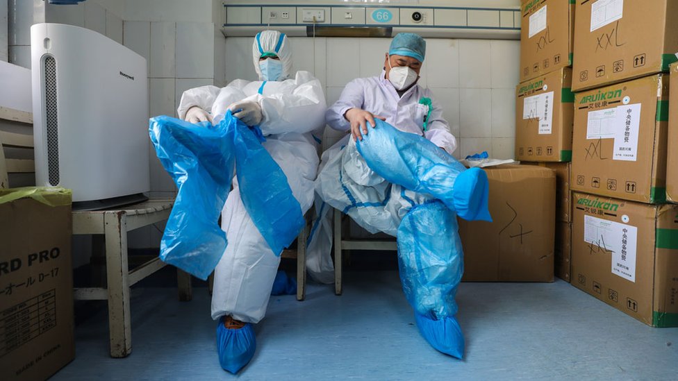 Two medical workers put on protective clothing at a hospital to treat coronavirus patients in Wuhan, China.