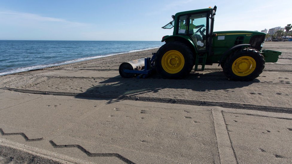 Un tractor demarca las áreas en la playa para los bañistas