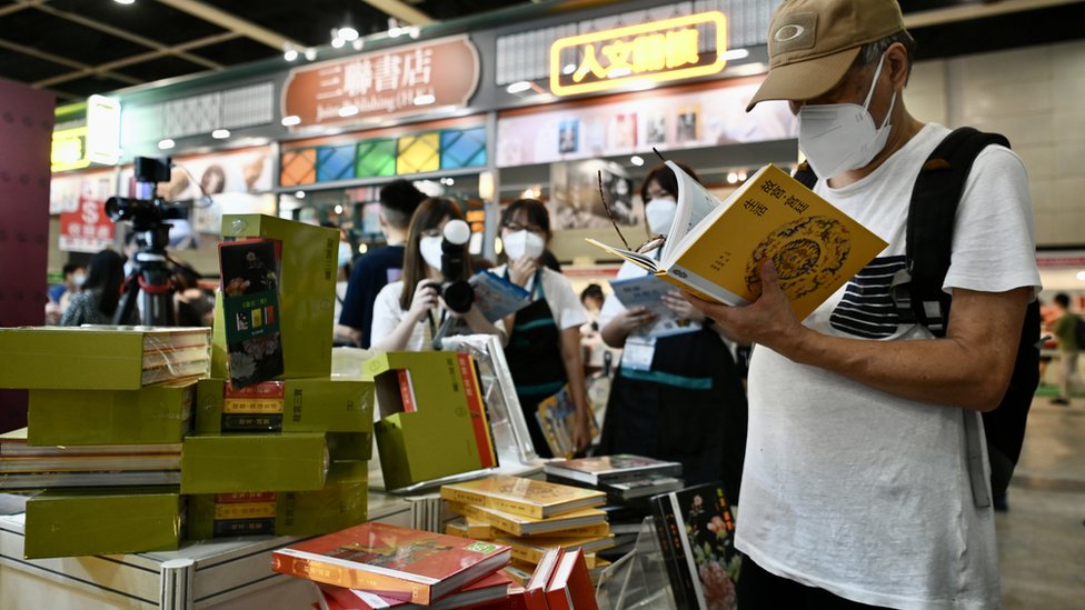 香港書展一書攤上一位讀者翻閲有關北京故宮的書籍（中新社圖片20/7/2022）