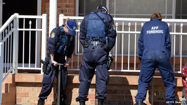 Группа криминалистов австралийской федеральной полиции осматривает передний двор дома в Сиднее