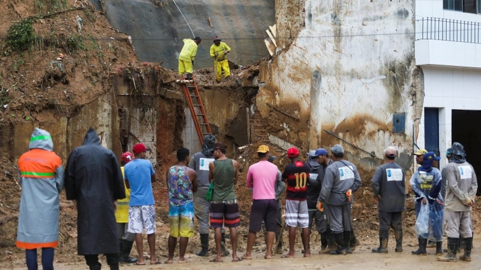 Ciudadanos miran mientras los trabajadores recogenescombros en Pernambuco