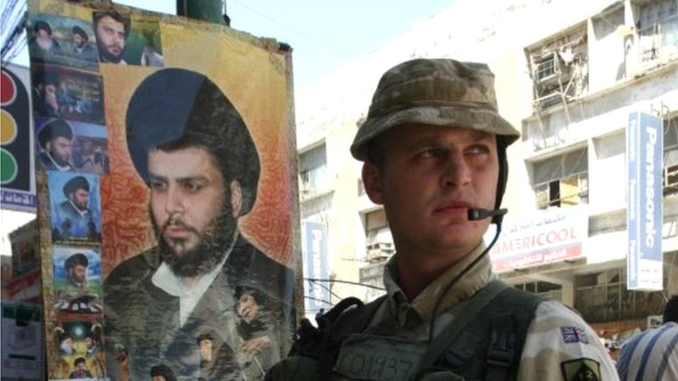 Британский солдат рядом с портретом Моктады ас-Садра в Басре, 2005 г.