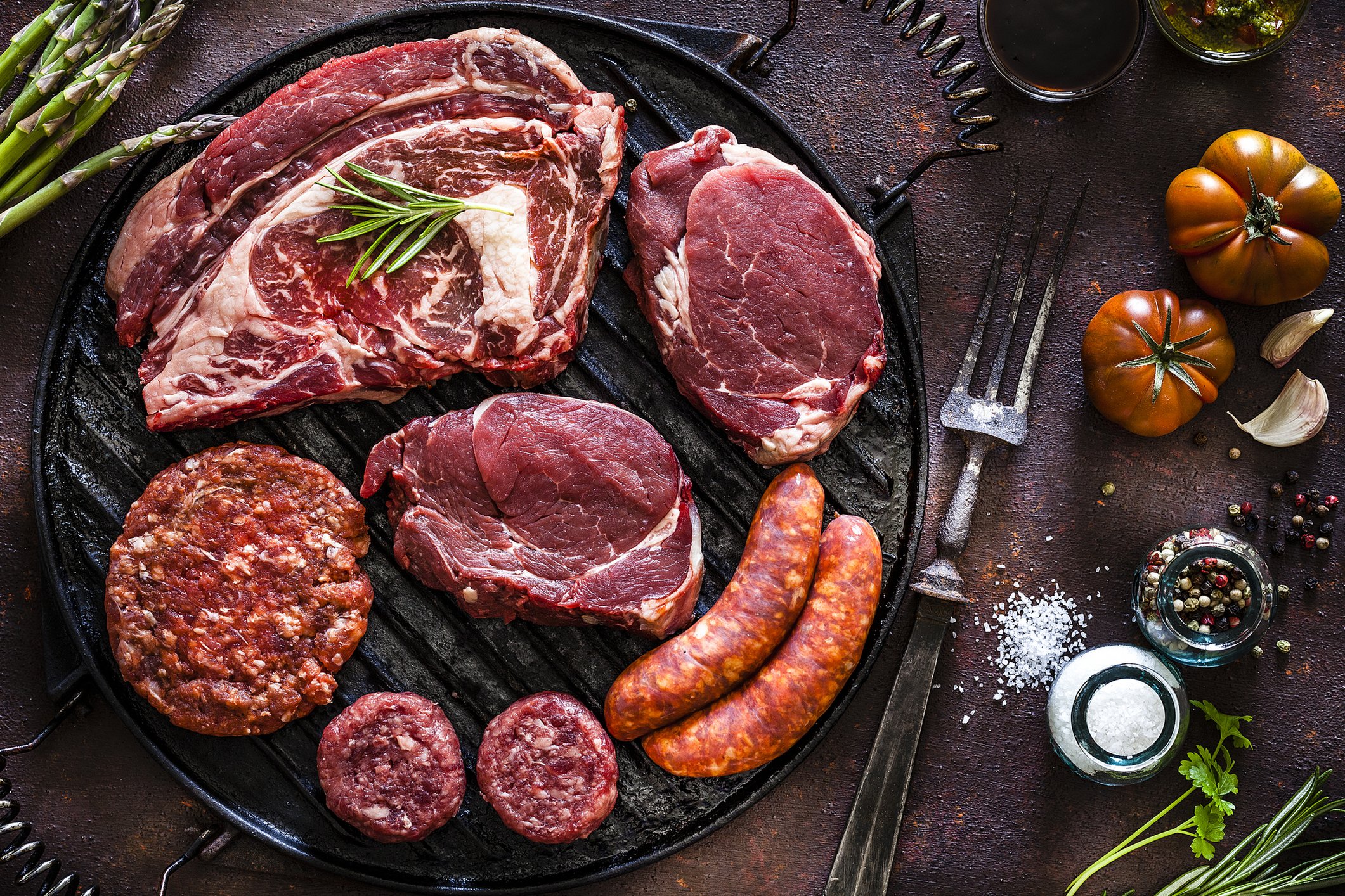 Various cuts of meat on an iron skillet