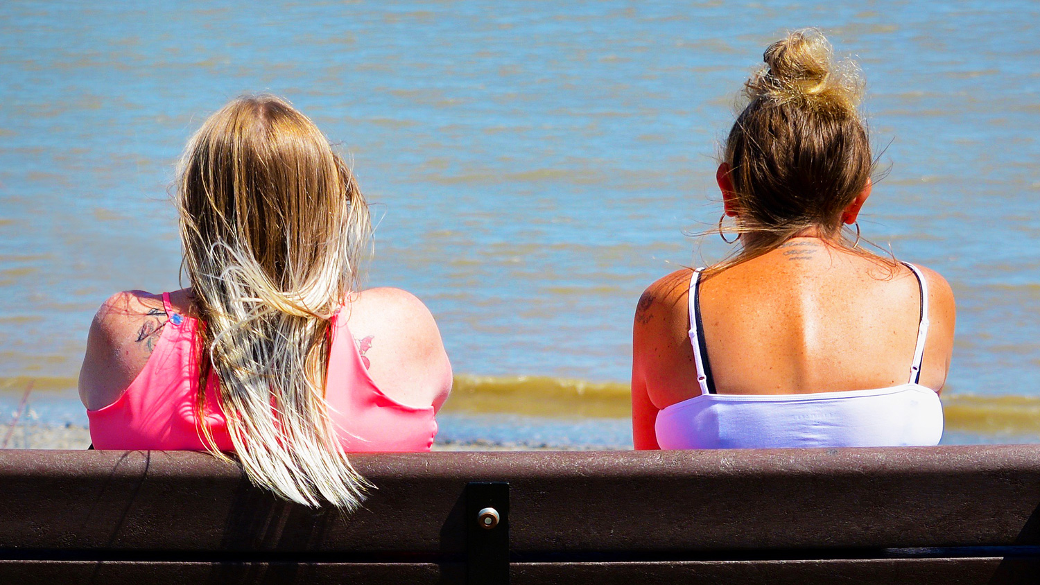 Две женщины на скамейке у моря