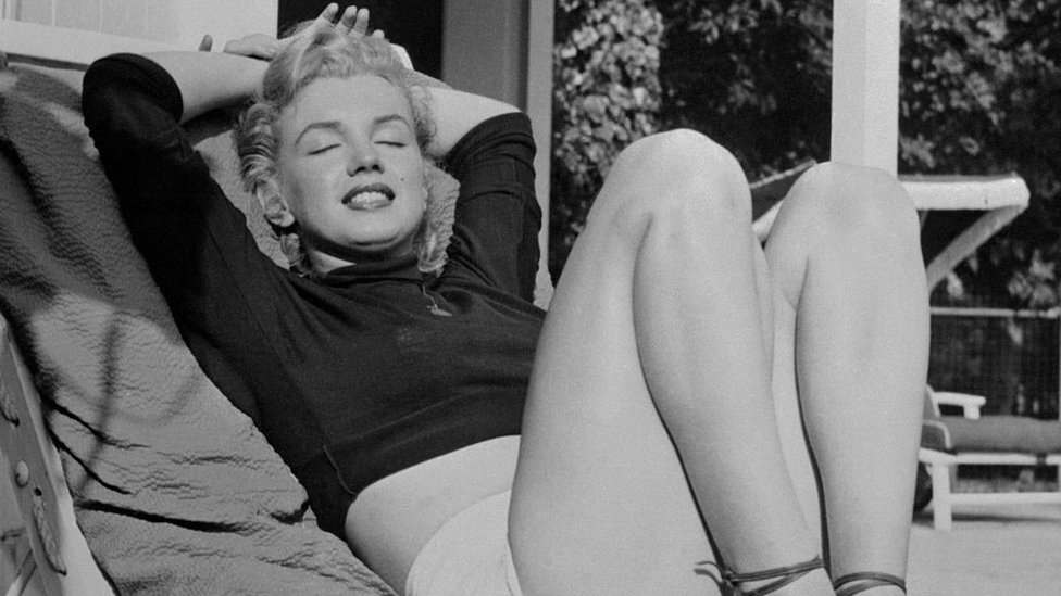 Hollywood film star Marilyn Monroe relaxes on a terrace, looking beautifully content in 1952