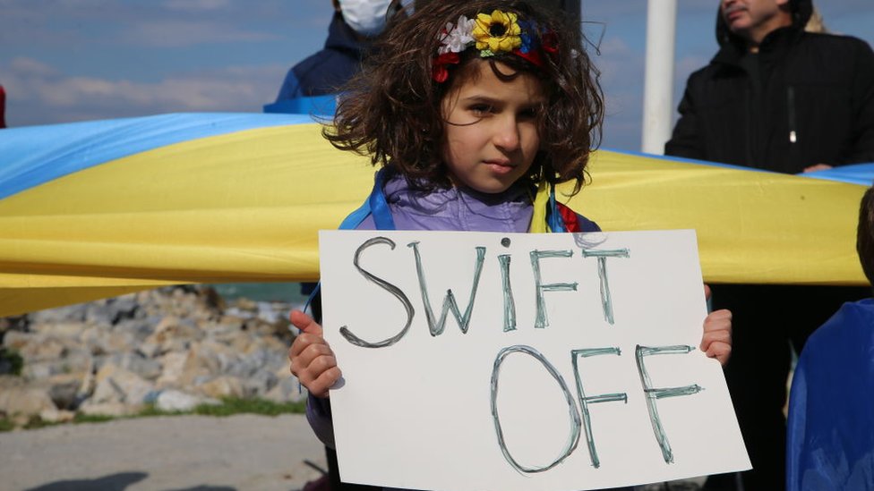 Girl holds a sign to exclude Russia from SWIFT