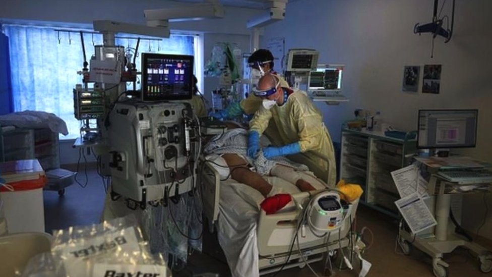Doktori pored pacijenta u bolničkom krevetu
