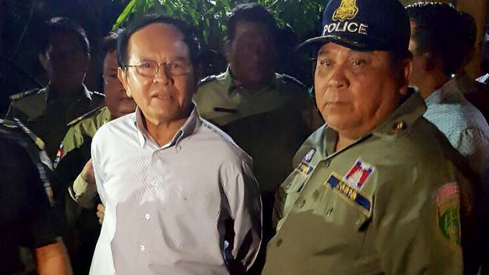 Лидер камбоджийской оппозиции Кем Соха (слева) в сопровождении полиции в его доме в Пномпене 3 сентября 2017 года.