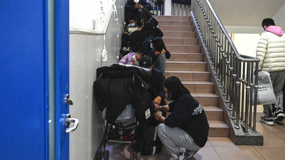 Children receive a drip on the stairs at a children hospital in Beijing on November 23, 2023.