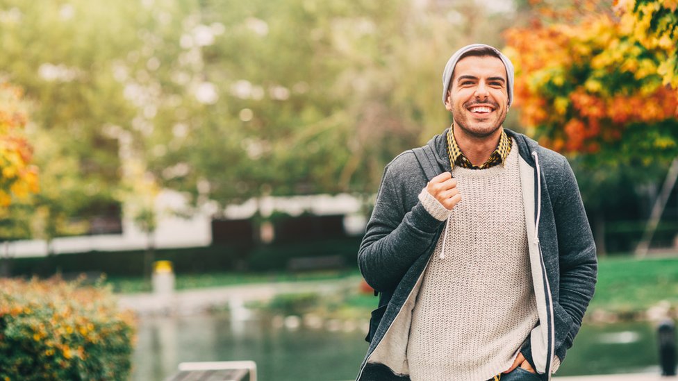 Sal a dar una vuelta por el parque a respirar aire libre. Joven caminando en el parque