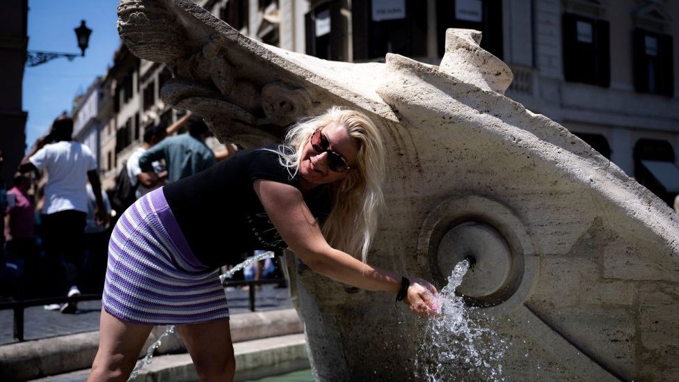 Gambar menunjukkan seorang wanita di air mancur di Roma