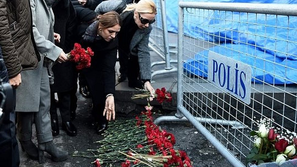 Цветы возложены рядом с турецкими полицейскими, стоящими на страже возле ночного клуба Reina, который был атакован вооруженным преступником в Стамбуле, Турция, 1 января 2017 года