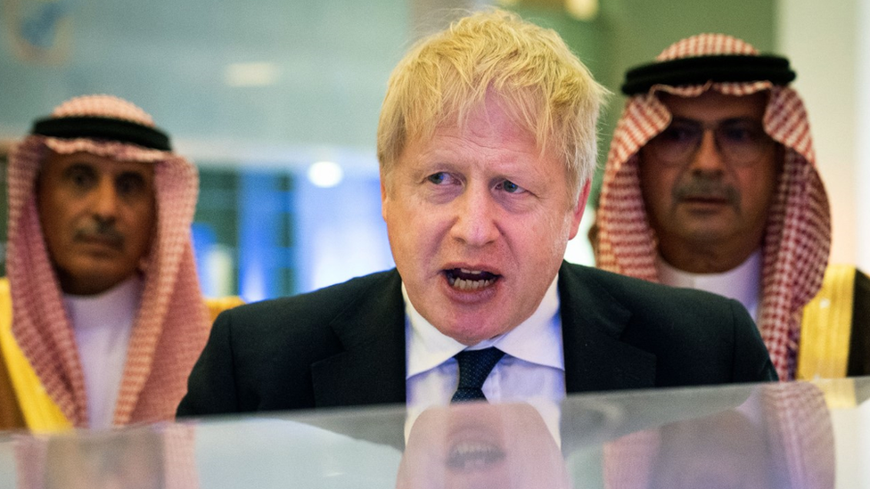 El primer ministro británico, Boris Johnston, pronuncia un discurso en Arabia Saudí, con representantes saudíes de fondo.
