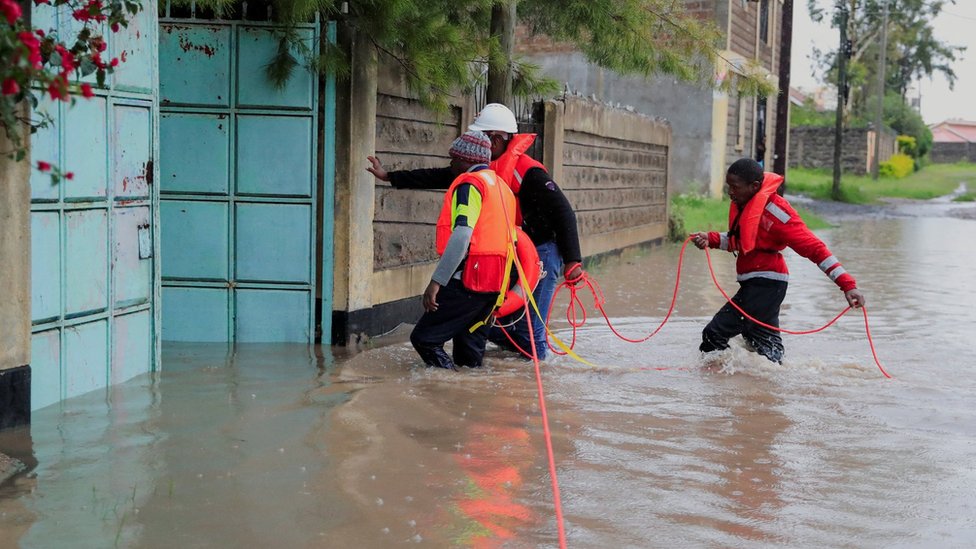 Kenya Red Cross staff wade through flood waters to reach residents trapped in their homes after a river burst its banks amid heavy rainfall in Kajiado County, Kenya - May 1 2024
