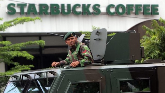An Indonesian soldier on guard in an armoured vehicle after a bomb blast in front of a Stabucks in Jakarta, Indonesia, 14 January 2016.