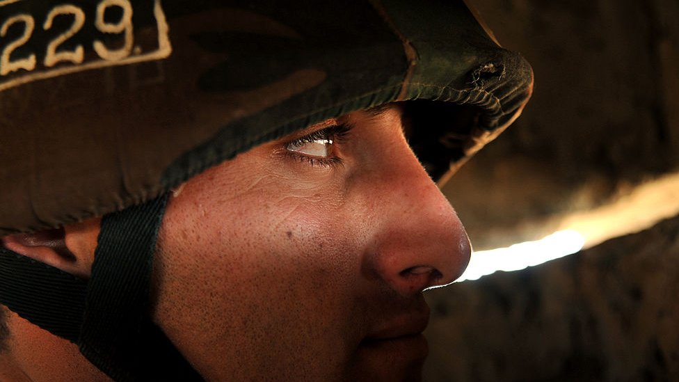 Armenian soldier in Nagorno-Karabakh looking through a slit of light.