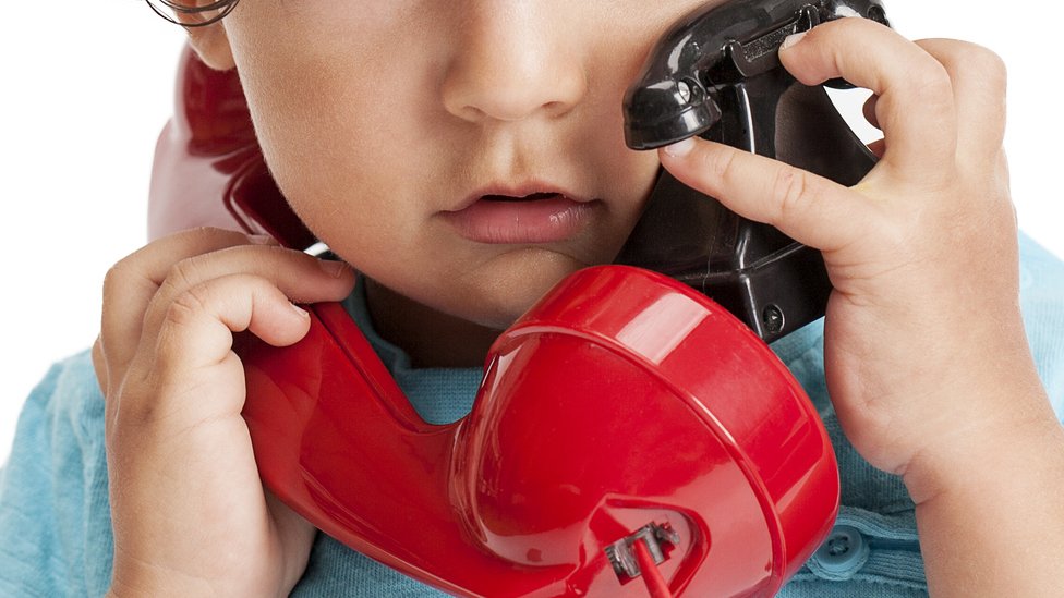 El tono del teléfono le daba cierto consuelo. niño con teléfono