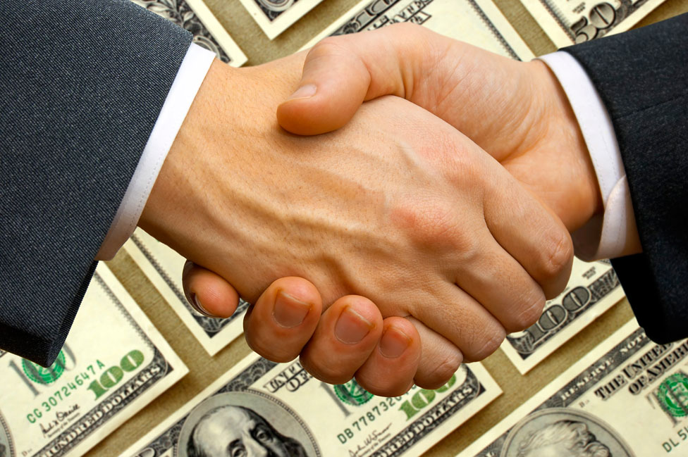 Dos hombres se dan la mano con un fondo de dólares
