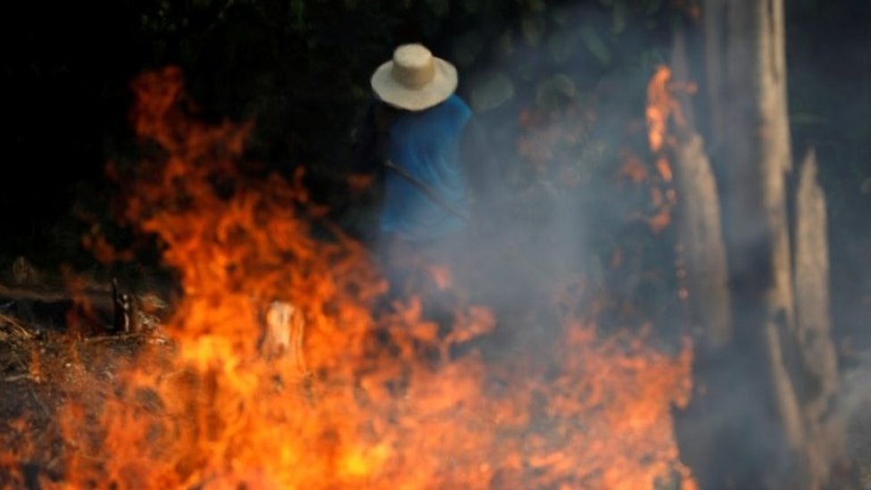 A man works in a burning tract of Amazon jungle as it is being cleared by loggers and farmers in Iranduba, Amazonas state, Brazil August 20, 2019.