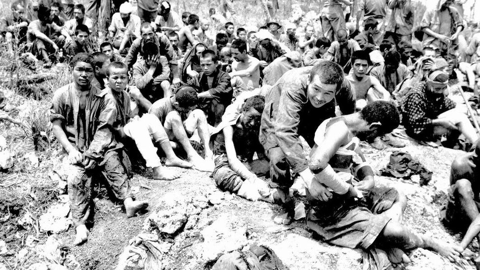 Residentes de Okinawa, algunos heridos, reunidos en un grupo tras rendirse a las fuerzas de EE.UU. en 1945.