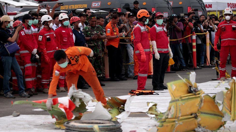Рабочие рассматривают части обломков разбившегося рейса Lion Air JT610