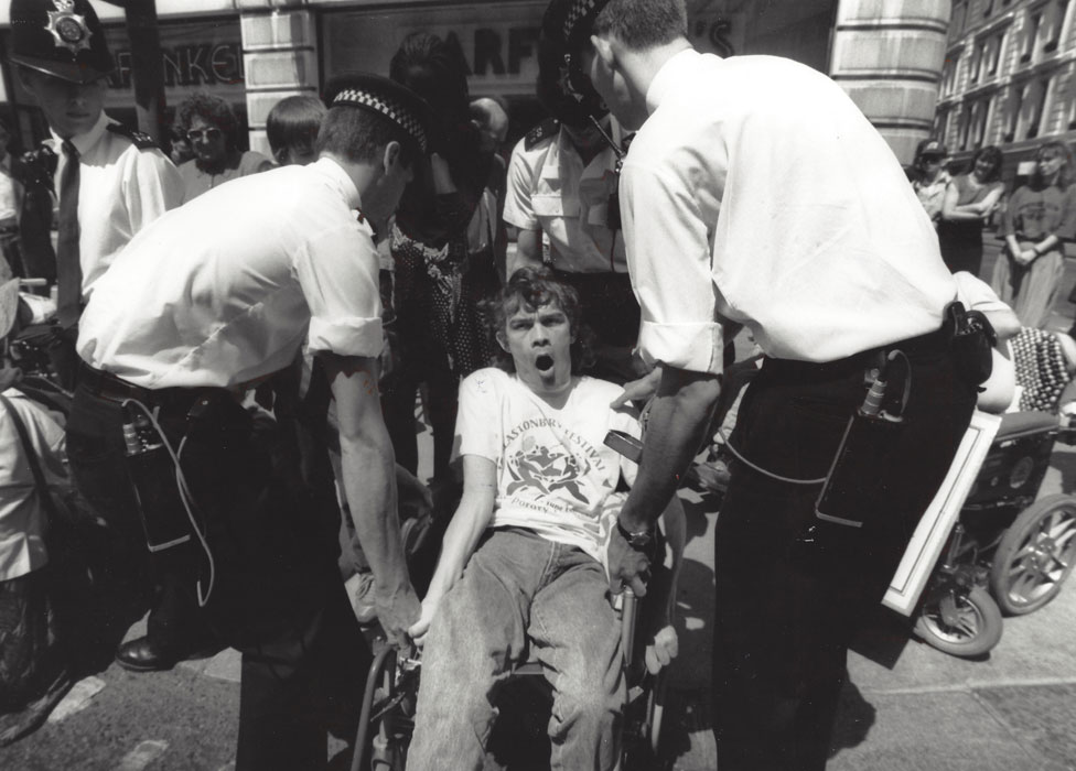 Wheelchair user being lifted by police