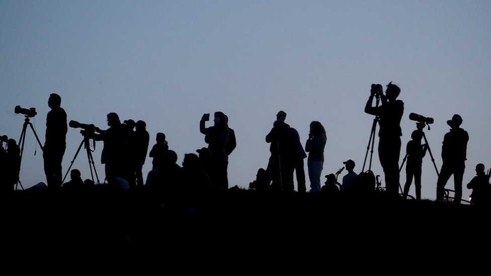 Silhouetted media members and people documenting the full moon, also known as the Supermoon or Flower Moon, over Primrose Hill, are seen in London, Britain