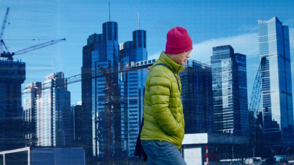 A man walks past a property developer's billboard in Beijing