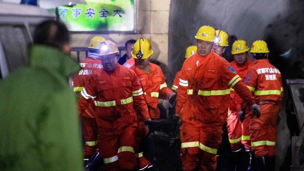 Спасатели несут пострадавшего на место взрыва угольной шахты в Пинъяо в начале 19 ноября 2019 г.