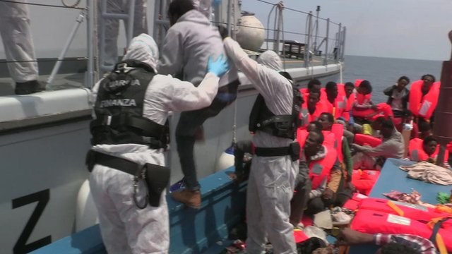 Migrant being hauled to safety