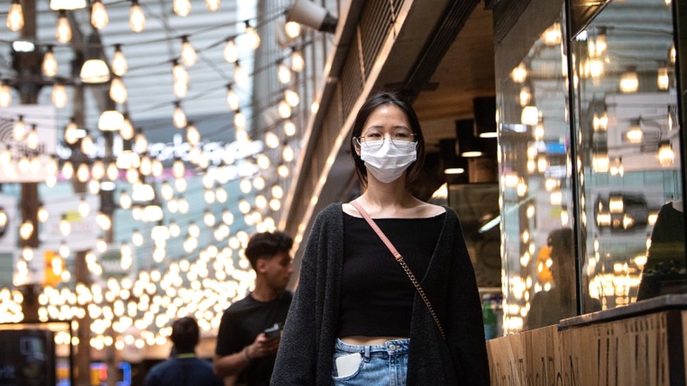 Женщина в защитной маске возле Уорлд-сквер Сидней, Австралия, 18 декабря 2020 года