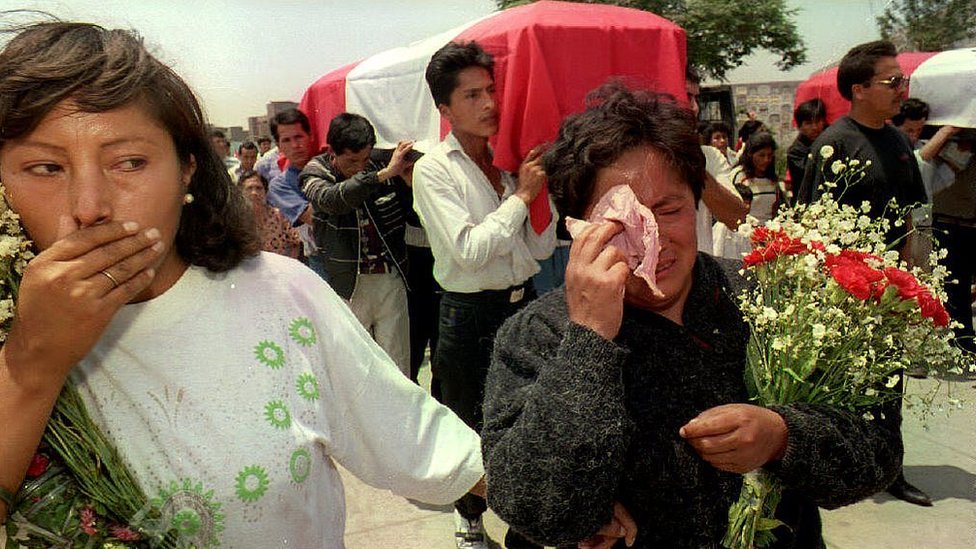 Mujeres lloran junto al ataúd de un policía víctima de Sendero.